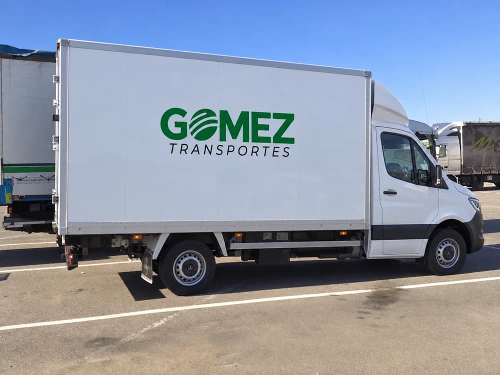 Furgón carrozado blanco de Transportes Gómez visto de lado